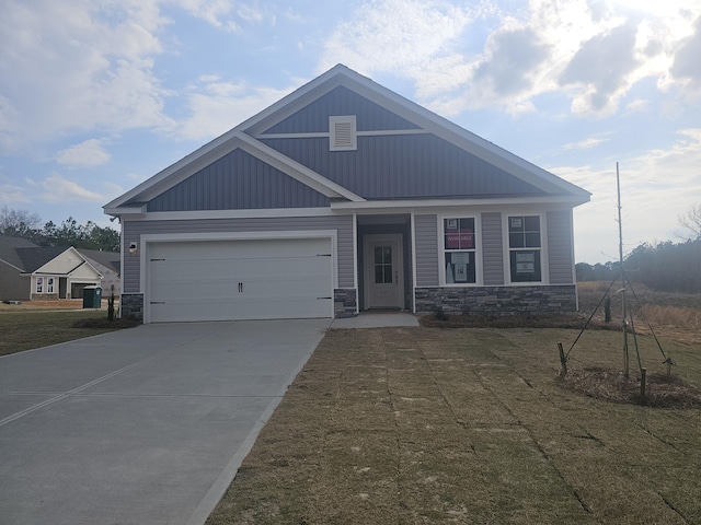 craftsman-style home with stone siding, an attached garage, and concrete driveway