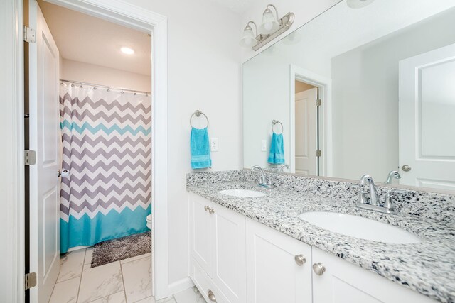 bathroom featuring vanity, toilet, and curtained shower