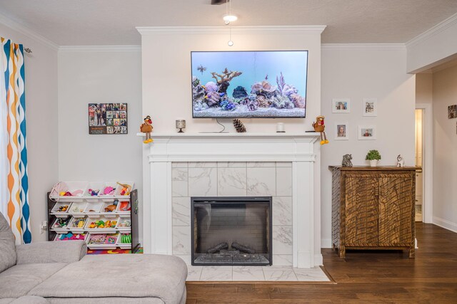 living room with hardwood / wood-style flooring, crown molding, and a tile fireplace