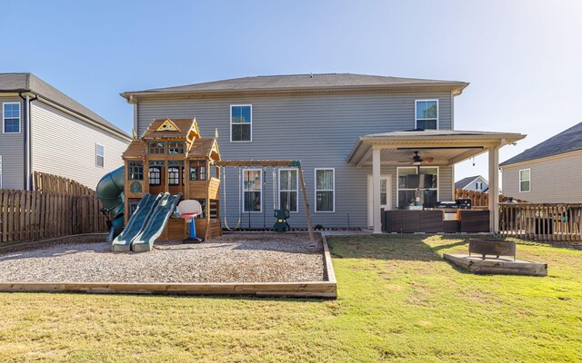 rear view of property with a playground, outdoor lounge area, ceiling fan, and a yard