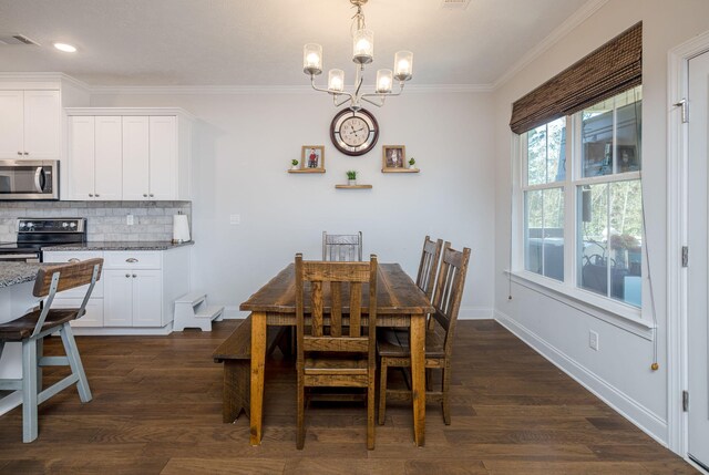 dining space with dark hardwood / wood-style floors, an inviting chandelier, and crown molding