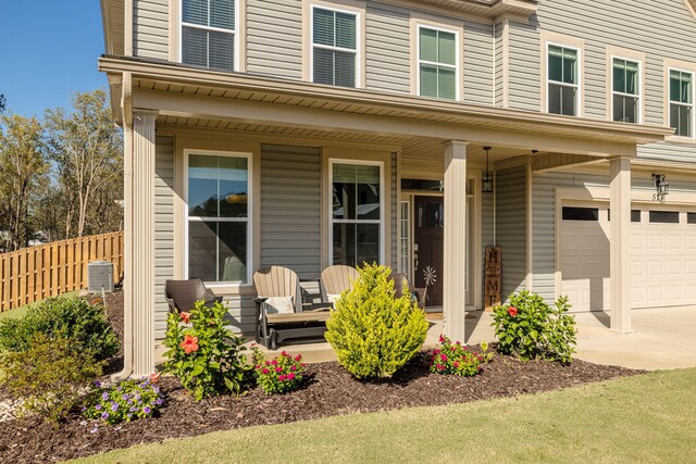 view of front of house featuring a porch, a garage, and central air condition unit