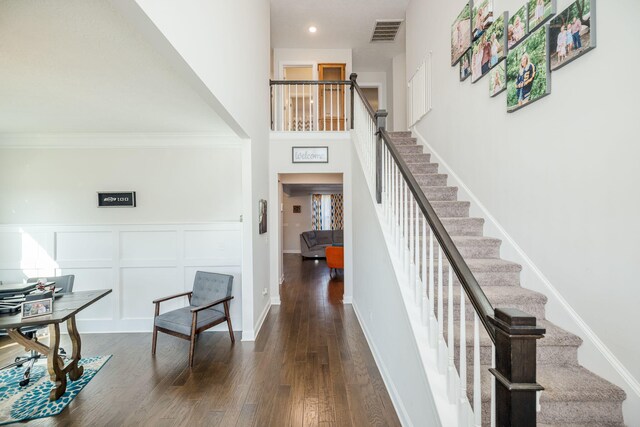 staircase featuring wood-type flooring and a towering ceiling