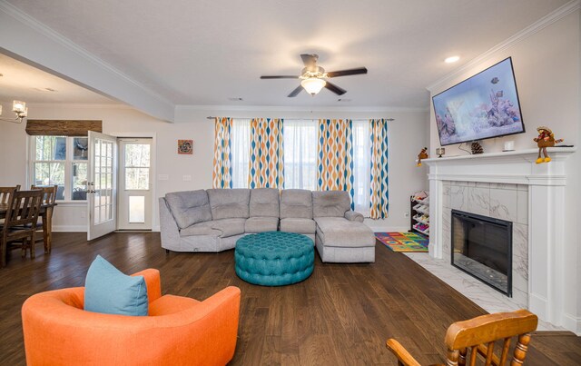 living room with hardwood / wood-style flooring, ceiling fan, ornamental molding, and a premium fireplace