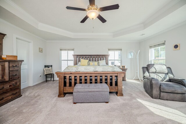 bedroom with ceiling fan, a raised ceiling, crown molding, and light carpet