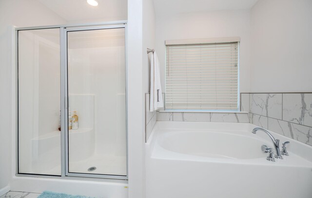 bathroom featuring shower with separate bathtub