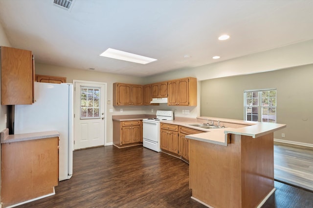 kitchen featuring white appliances, a peninsula, visible vents, under cabinet range hood, and a sink