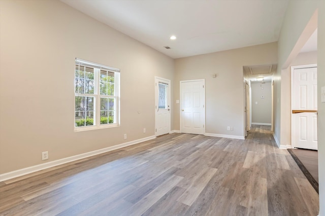 empty room featuring light wood-style flooring, visible vents, recessed lighting, attic access, and baseboards