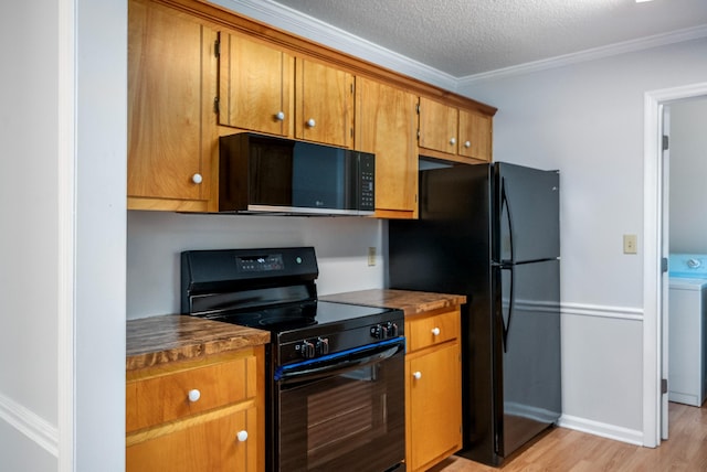 134 Robin Rd, Barnwell, SC 29812 - kitchen featuring black appliances, washer / dryer, light wood-style flooring, brown cabinets, and ornamental molding