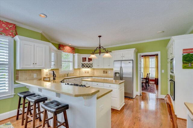 3501 Lonesome Pine Ct, Martinez, GA 30907 - kitchen with stainless steel appliances, a sink, light countertops, a peninsula, and white cabinetry