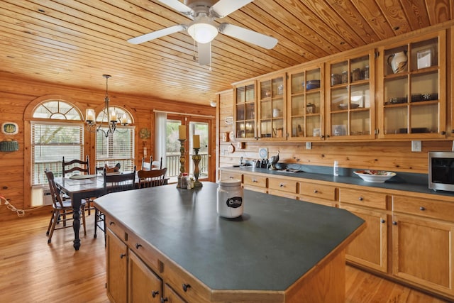 kitchen featuring dark countertops, stainless steel microwave, a wealth of natural light, and wooden ceiling