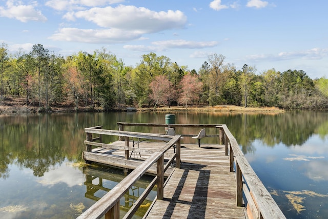 view of dock featuring a view of trees and a water view