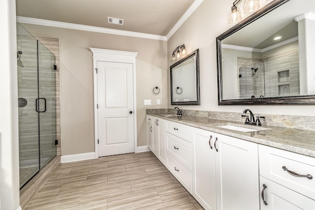 full bathroom featuring ornamental molding, a stall shower, a sink, and visible vents