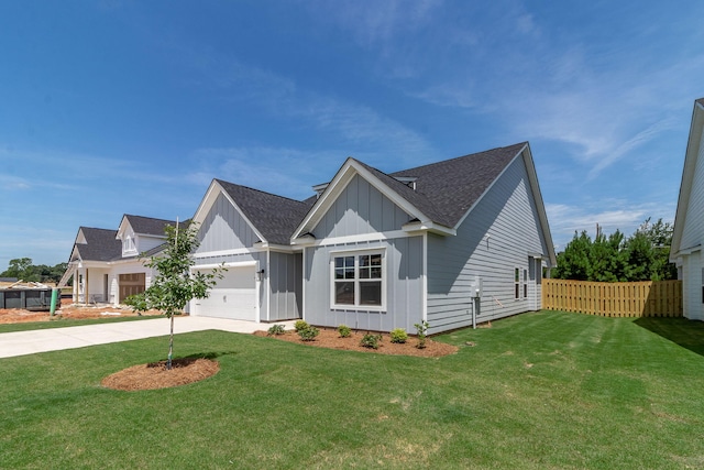 view of front of home featuring driveway, an attached garage, fence, board and batten siding, and a front yard