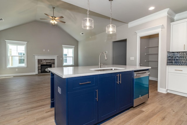 kitchen with dishwasher, light wood-style floors, a sink, and blue cabinets