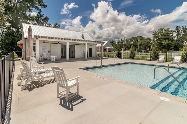 pool with a patio and fence