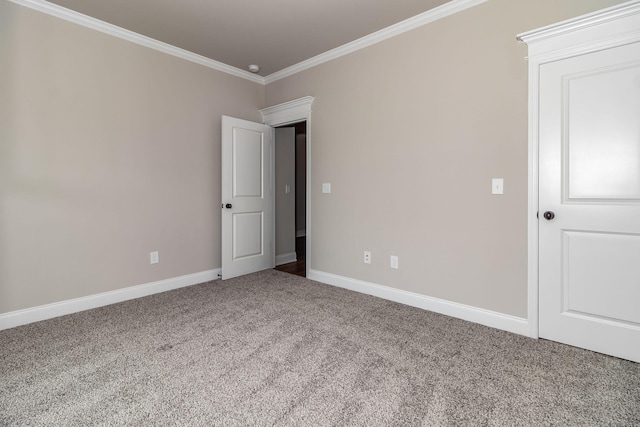 empty room featuring ornamental molding, carpet, and baseboards