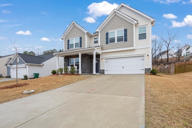 view of front of property with fence, concrete driveway, covered porch, a garage, and stone siding