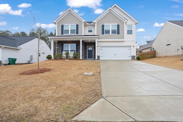 view of front of home with stone siding, driveway, an attached garage, and a front lawn