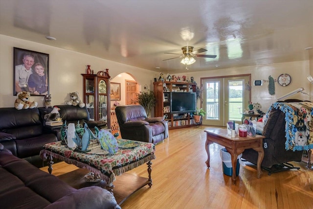 living room featuring ceiling fan, light hardwood / wood-style flooring, and french doors