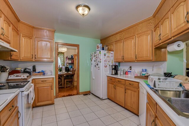 kitchen with sink, light tile patterned flooring, a chandelier, and white appliances