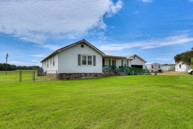 back of house with covered porch and a yard