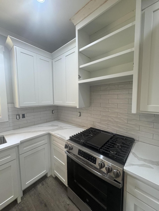 314 Hancock Cir, Mccormick, SC 29835 - kitchen with stainless steel gas stove, dark wood-style floors, open shelves, white cabinets, and decorative backsplash