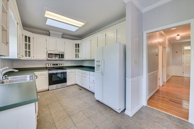 227 Water Oak Dr, Augusta, GA 30904 - kitchen with appliances with stainless steel finishes, ornamental molding, light tile patterned flooring, dark countertops, and white cabinets