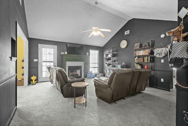 carpeted living area featuring a fireplace, visible vents, vaulted ceiling, and a wealth of natural light