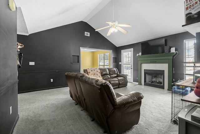 living area featuring carpet floors, visible vents, vaulted ceiling, and a fireplace