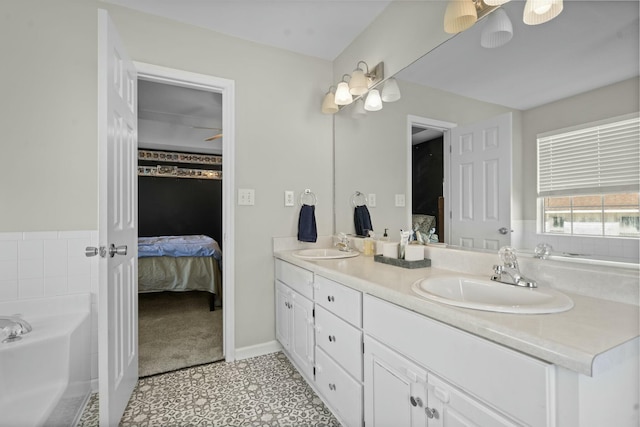 ensuite bathroom with ensuite bathroom, double vanity, a sink, and a bath