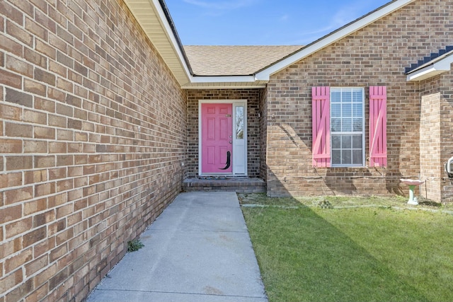 doorway to property featuring roof with shingles and brick siding