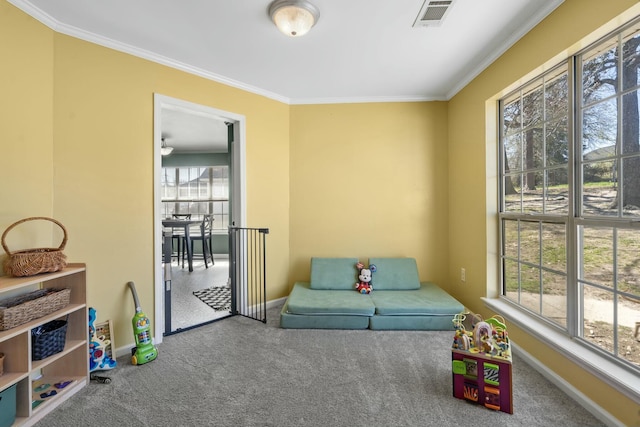 living area with carpet floors, visible vents, and crown molding