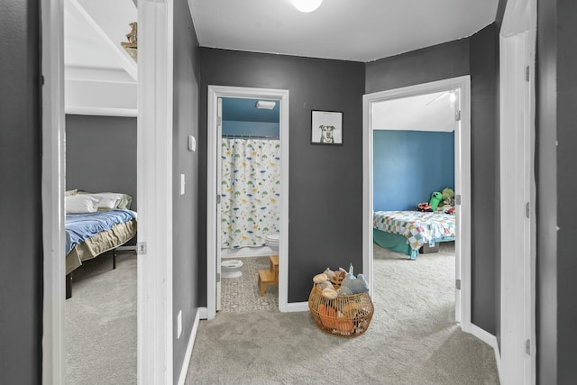 hallway featuring baseboards and carpet flooring