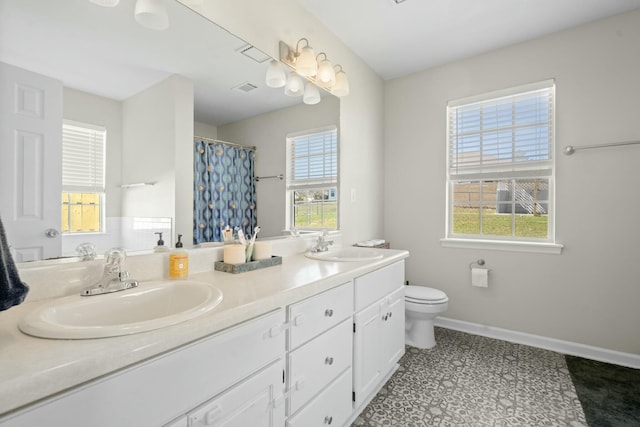 full bathroom featuring a wealth of natural light, a sink, and toilet