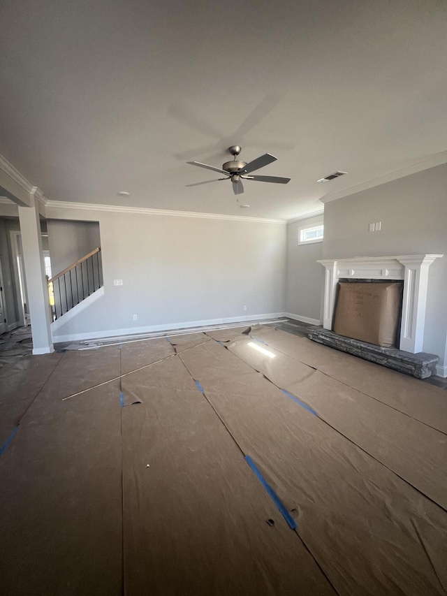 unfurnished living room featuring a fireplace with raised hearth, ornamental molding, visible vents, and a ceiling fan