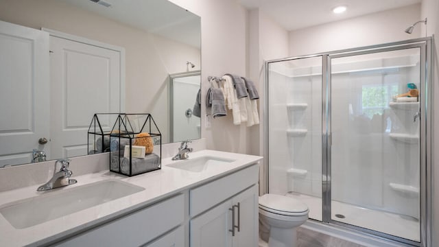 bathroom with toilet, vanity, and walk in shower