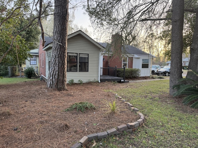 view of front facade with a chimney and a front yard