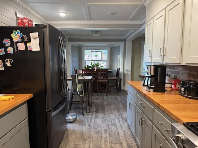 kitchen with crown molding, wooden counters, freestanding refrigerator, and wood finished floors