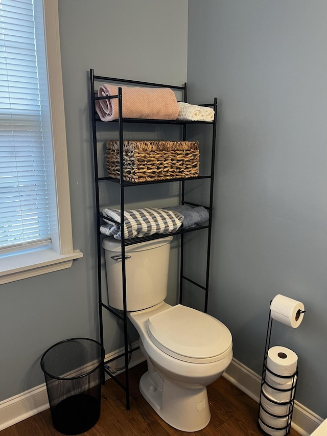 bathroom featuring toilet, wood finished floors, and baseboards