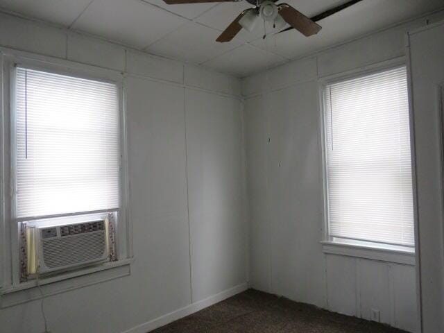 carpeted spare room featuring ceiling fan and cooling unit