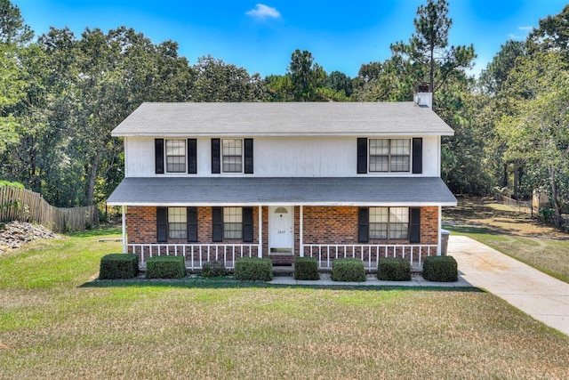 view of front of house with covered porch and a front lawn