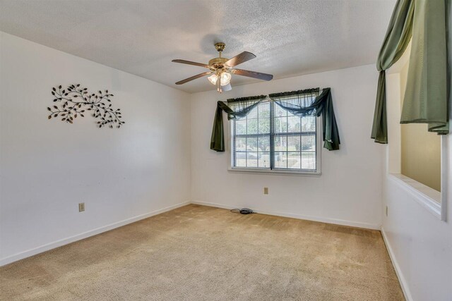 carpeted spare room with ceiling fan and a textured ceiling