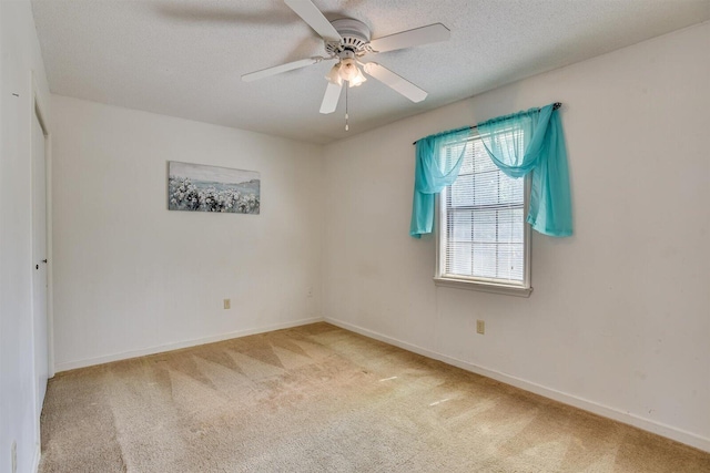 empty room with ceiling fan, carpet, and a textured ceiling