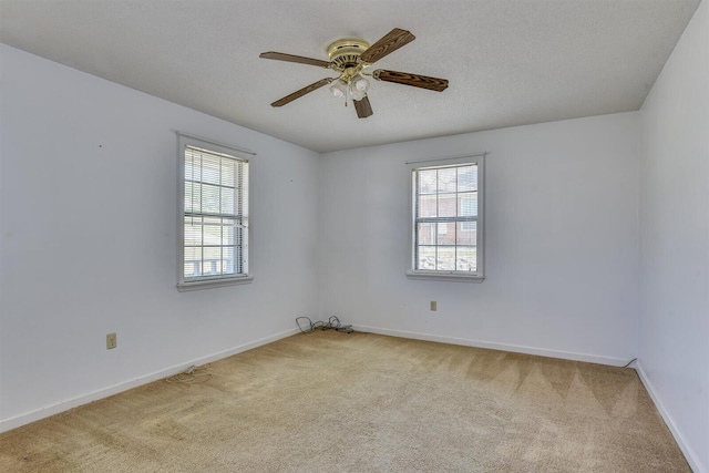 carpeted empty room with ceiling fan and a textured ceiling