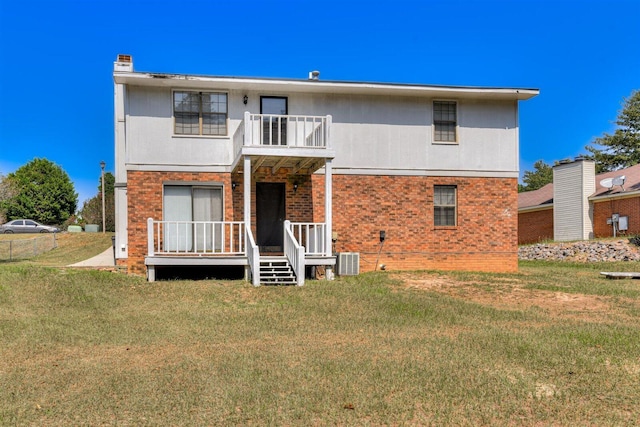 rear view of house featuring a yard, a balcony, and central AC unit