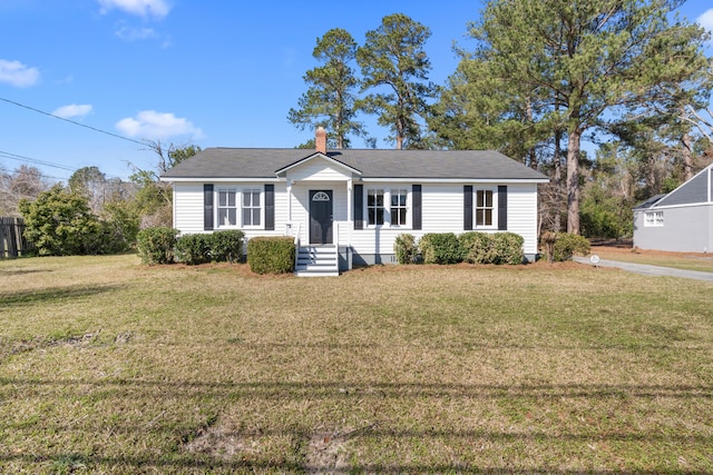 view of front of property with a chimney and a front lawn