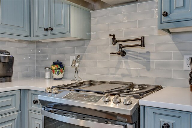710 Somerset Way, Augusta, GA 30909 - kitchen with stainless steel gas range oven, decorative backsplash, light countertops, and blue cabinetry