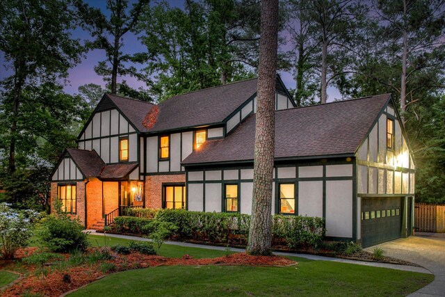 710 Somerset Way, Augusta, GA 30909 - tudor-style house with concrete driveway, a lawn, roof with shingles, a garage, and brick siding