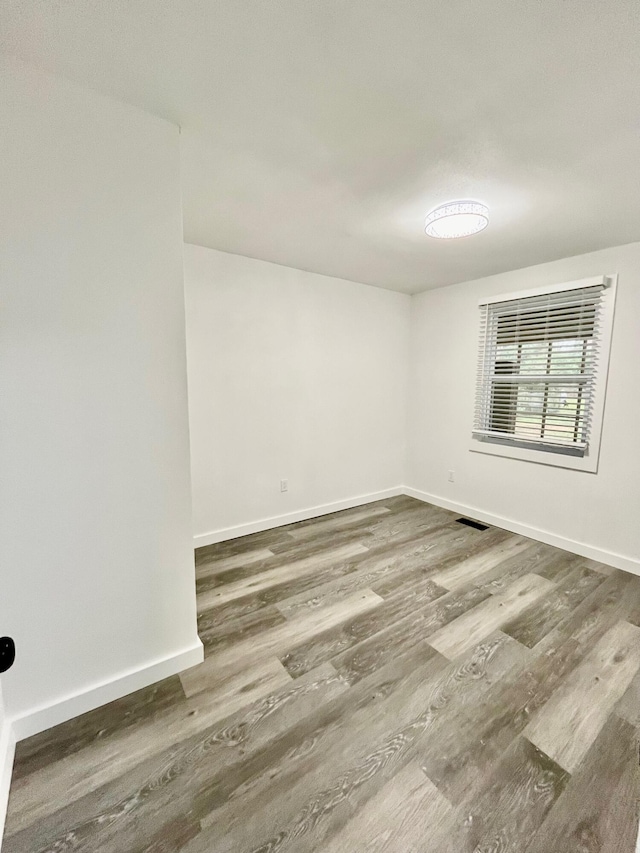 unfurnished room with dark wood-type flooring